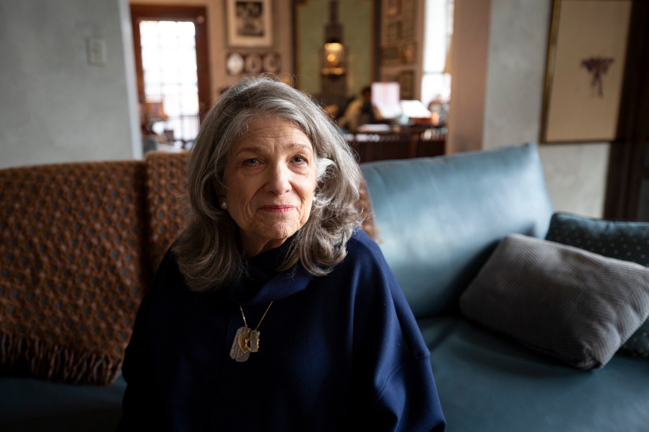 Carol Boigon sits on her sofa at home.