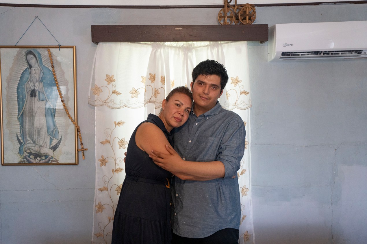 growing-up-scared-mental-health-013-web A man and woman embrace as they stand in front of a window and pose for a portrait