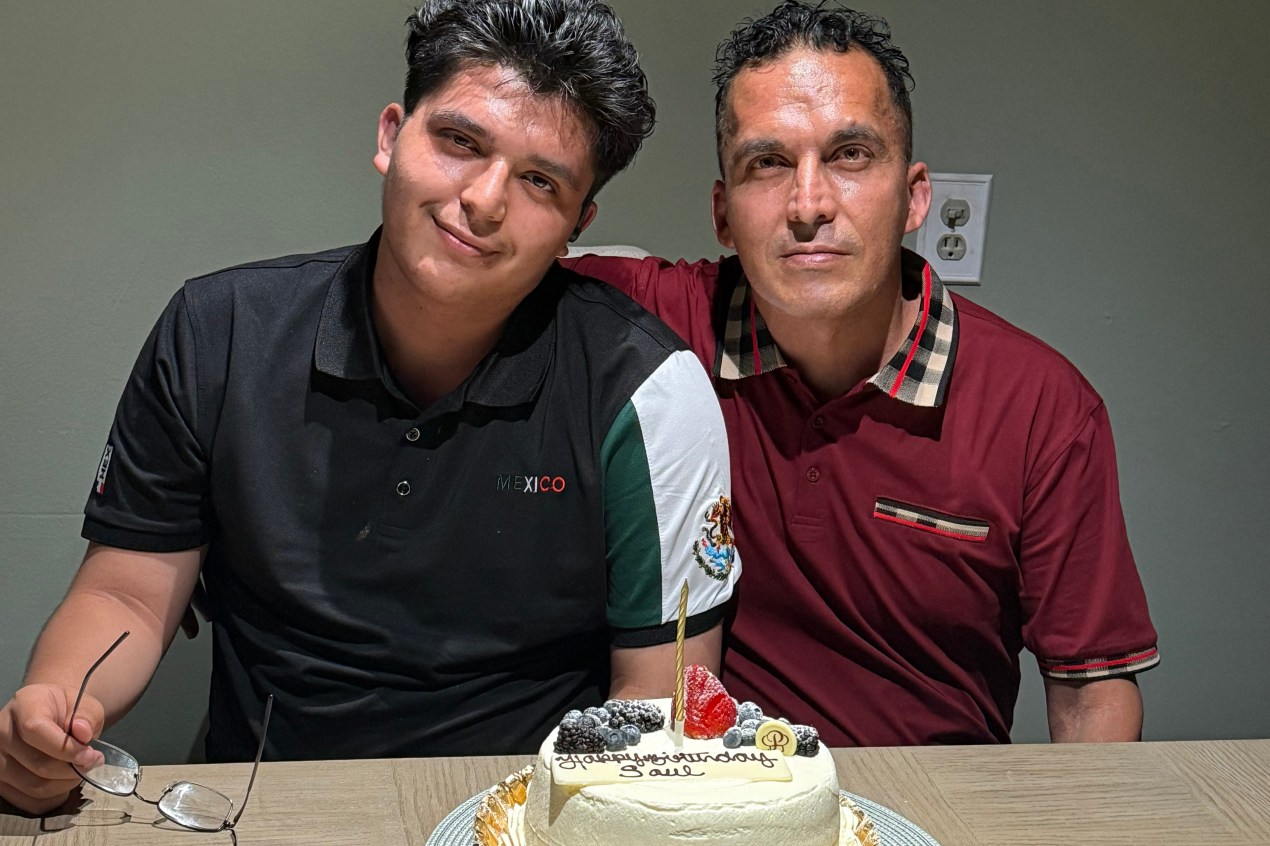 growing-up-scared-mental-health-015-web Two men sit at a table in front of a birthday cake as they smile for a portrait