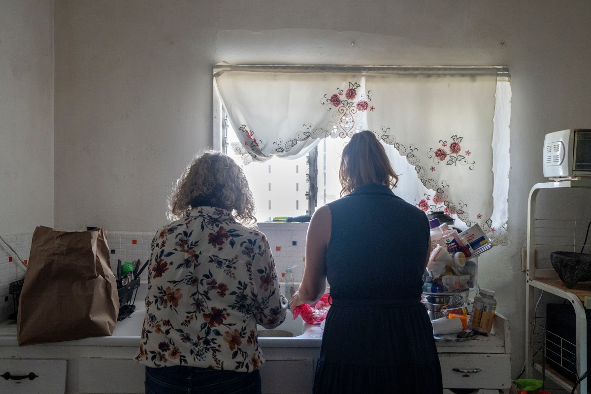 growing-up-scared-mental-health-08-web Two women stand in front of a sink and a window as they prepare food in a kitchen