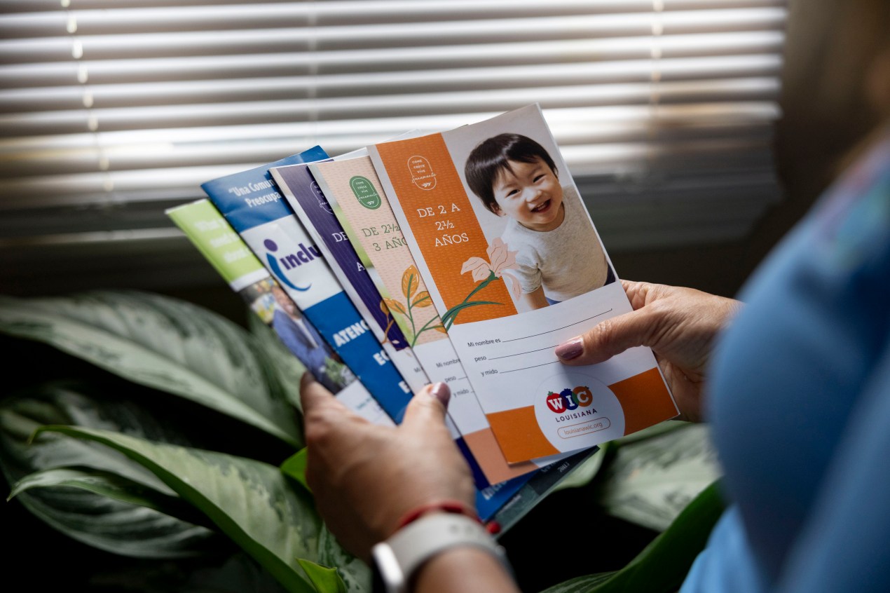A close-up of hands holding several colorful brochures.