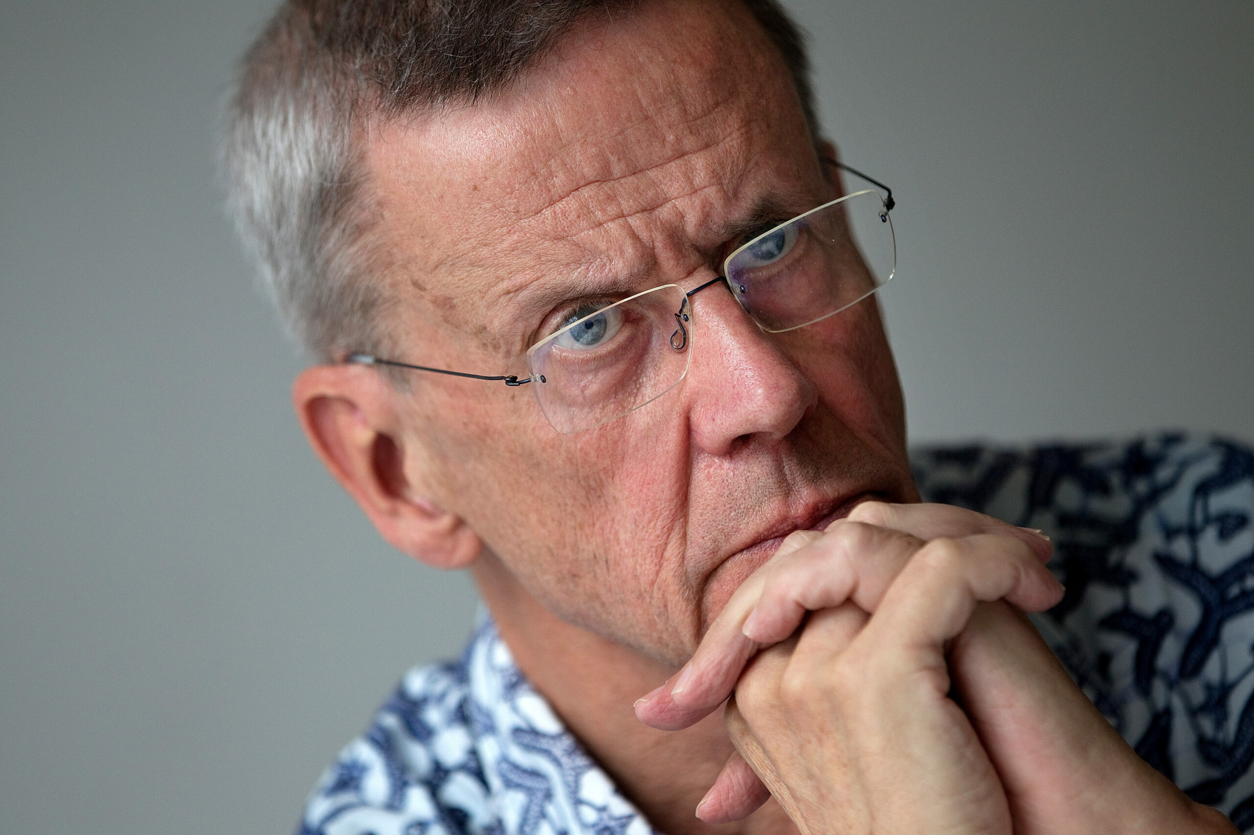 Peter Aaby sits at a table with his hands clasped. He rests his hands against his chin.