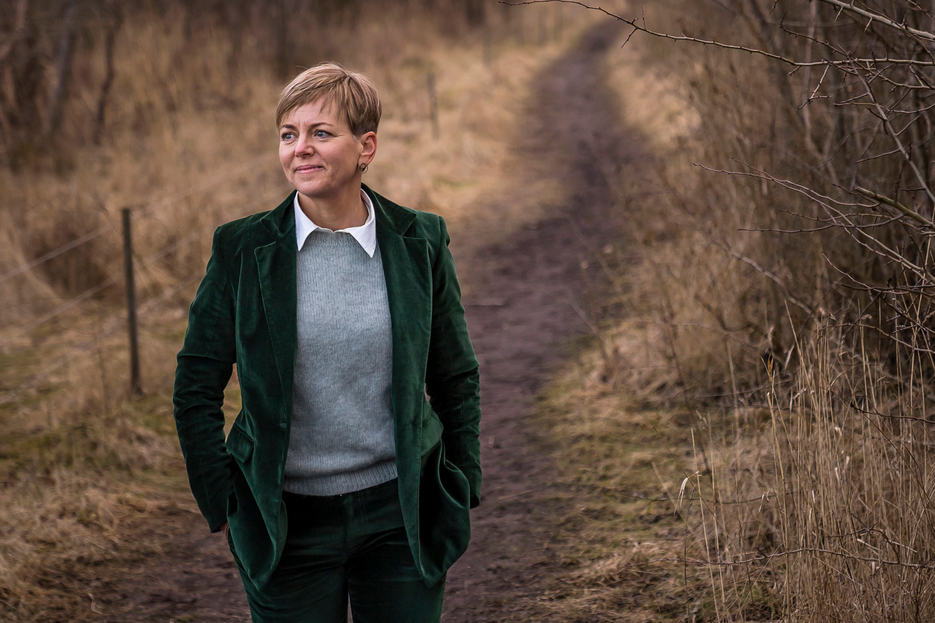 A Danish woman walks down a dirt road.