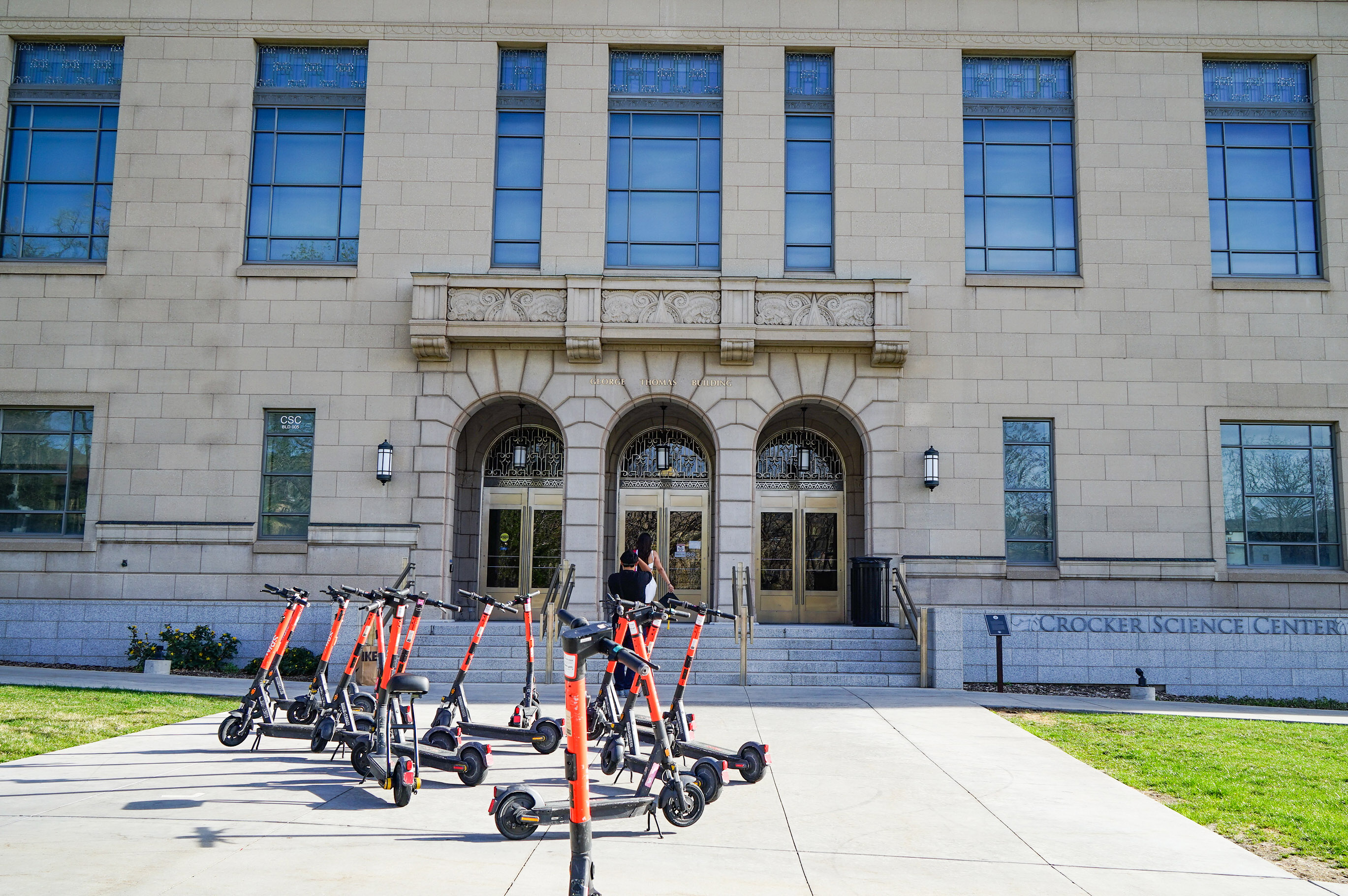 utahmeasles_08 A photo of a university building with several electric scooters parked in front of it.