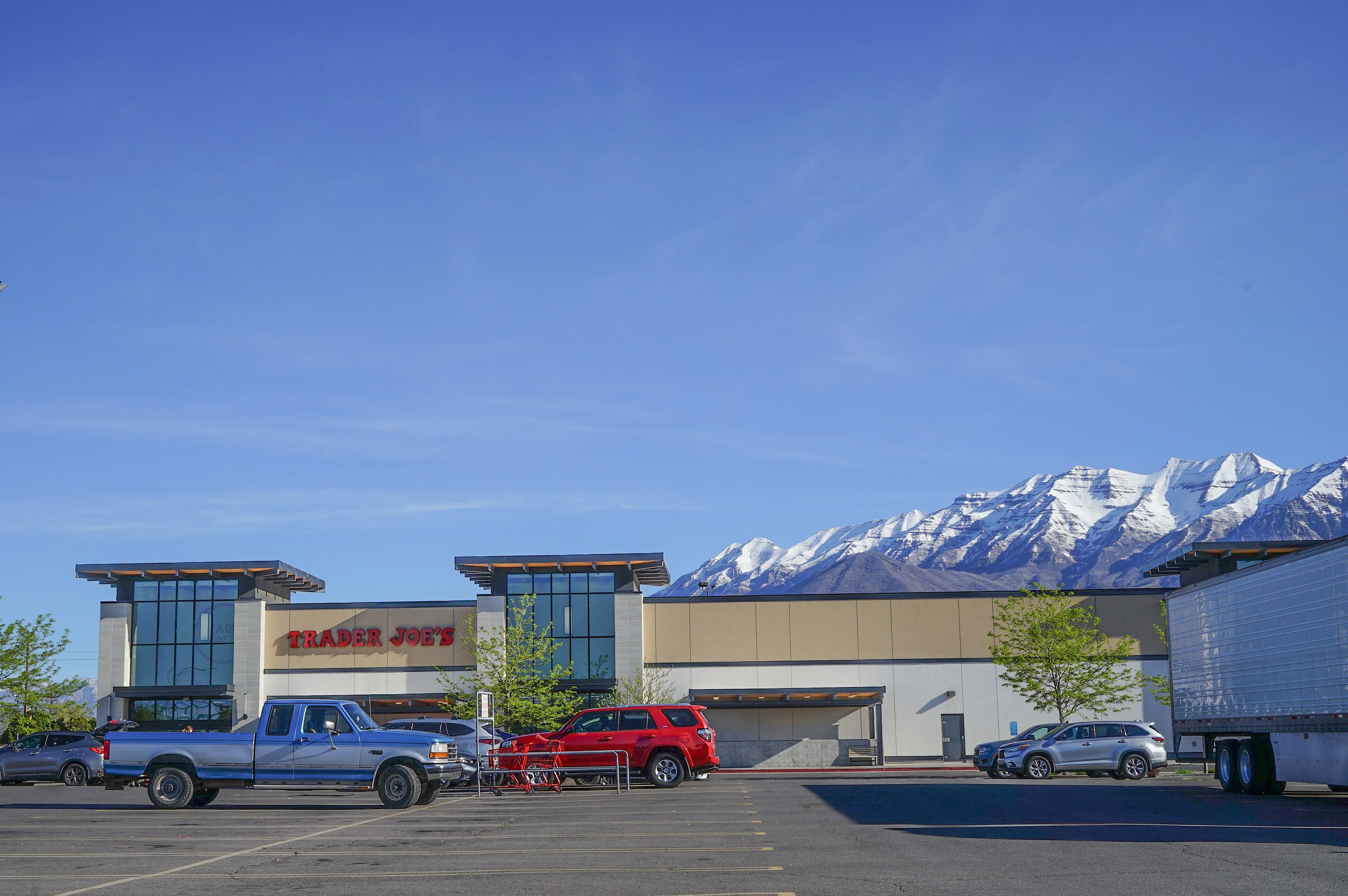 utahmeasles_09 A photo of a Trader Joe's parking lot. Mountains are seen peaking out from behind the building.
