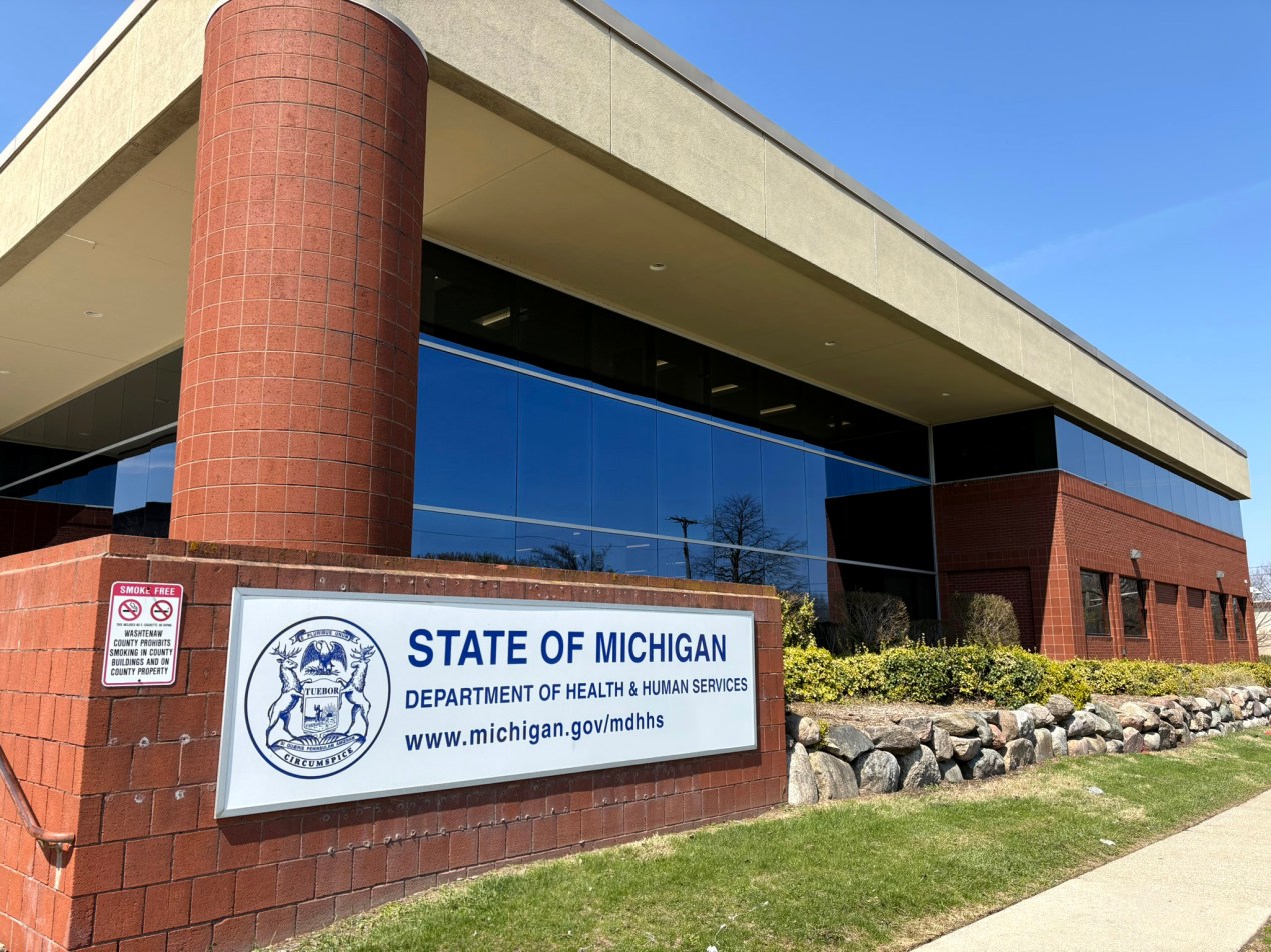 The exterior of an office building with a sign that says "State of Michigan, Department of Health & Human Services"